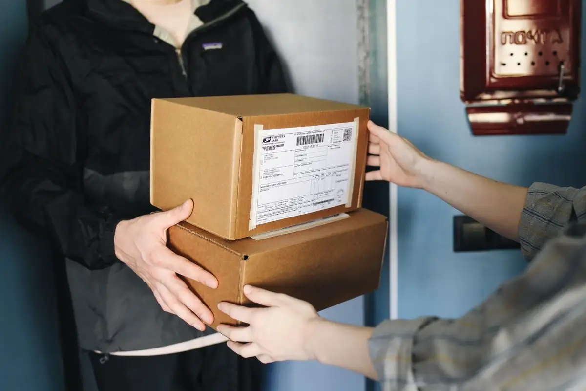 Courier handing an ecommerce parcel to a customer at the door in Dubai